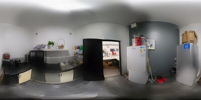 The kitchen, with sink, worktops, cupboards and fridge, opening onto the reception lobby.