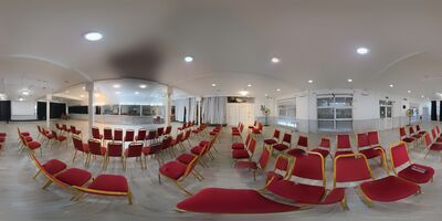The main hall laid out with chairs, looking towards the fire exit, the shuttered windows and the door back to the lobby.