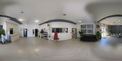 The reception lobby and front entrance, with the desk, the counter and the doors through to the hall, the kitchen and the toilets.